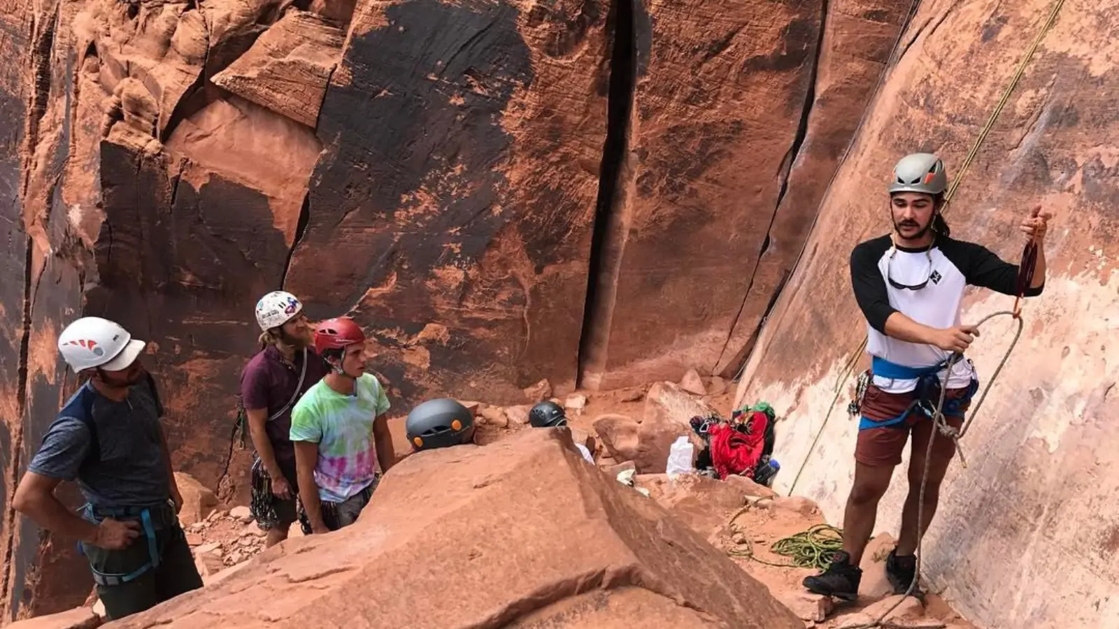 A man demonstrates the proper climbing technique to three men.