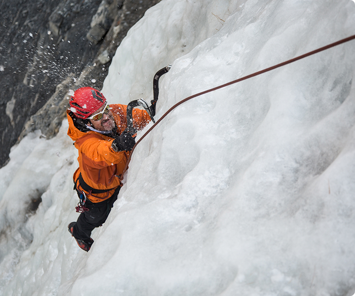 man swinging an ice axe into ice