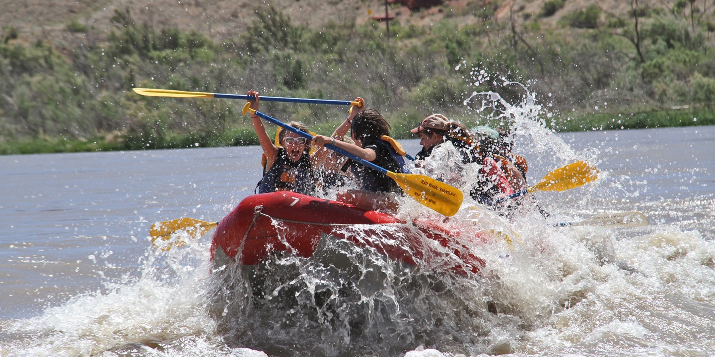People in a red raft on the fisher towers rafting stretch in moab
