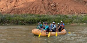 People in a yellow raft floating down the river in Moab
