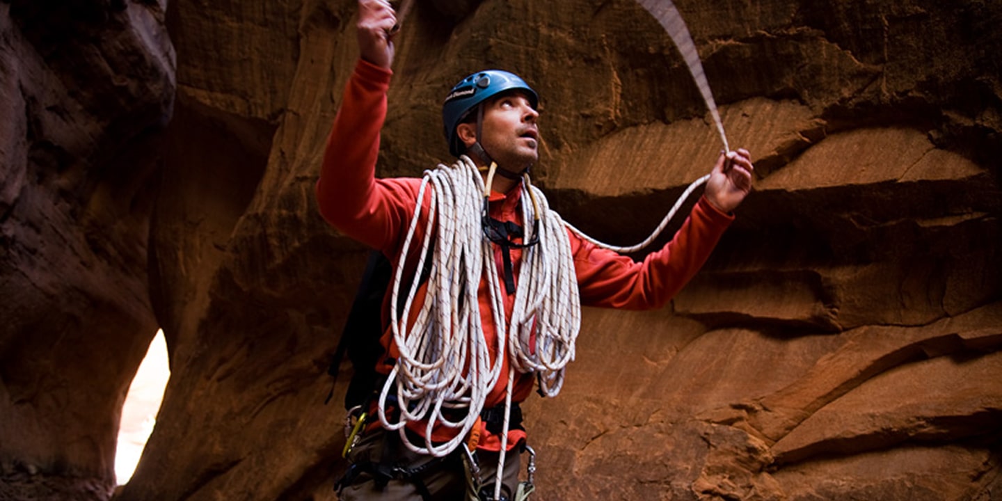 A man organizes his rope after rappeling in moab