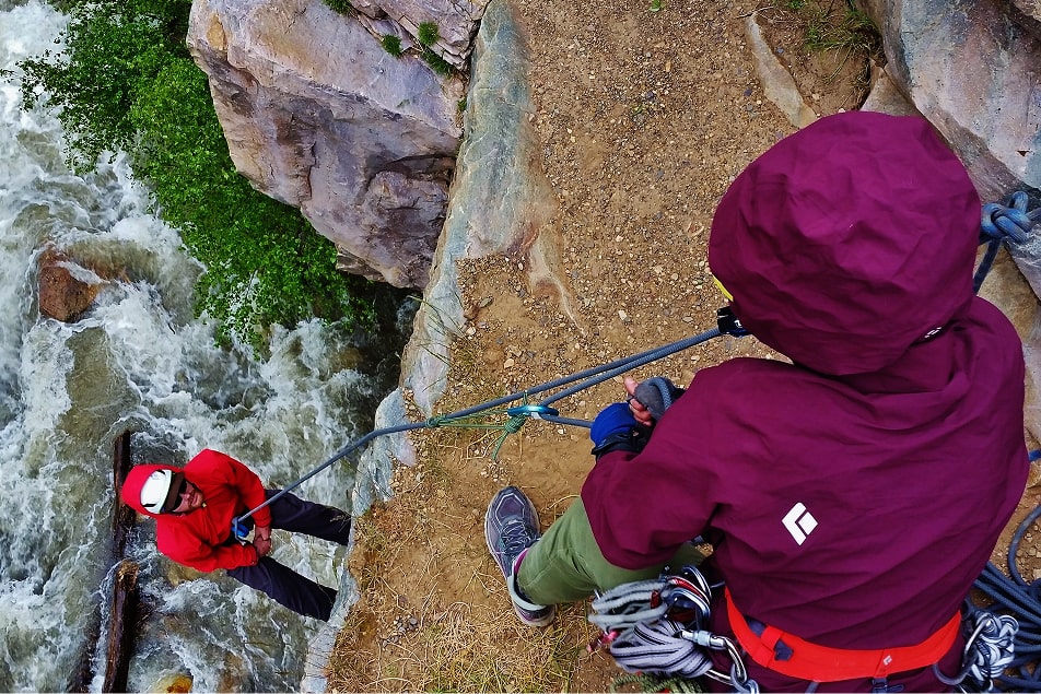 One person belays another from above while rock climbing