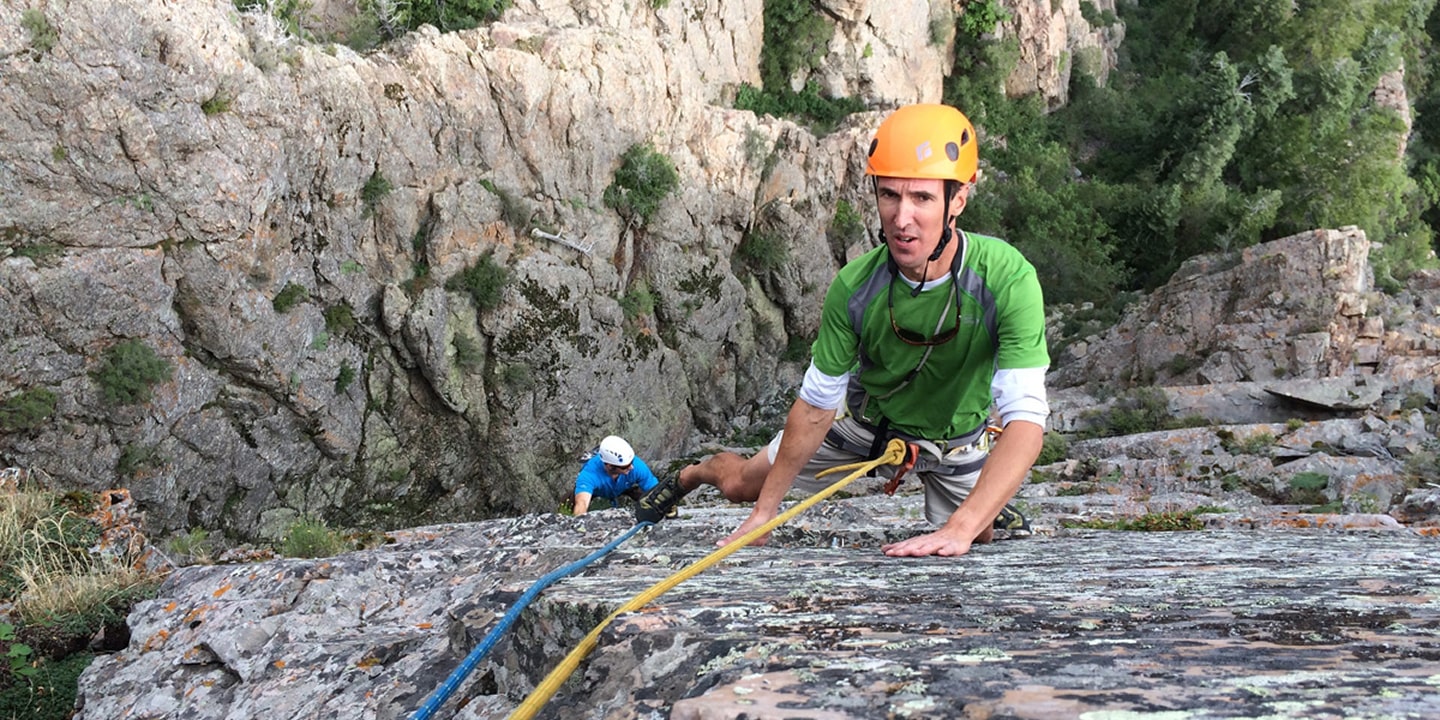 A man pauses for a break during a multi-pitch climb