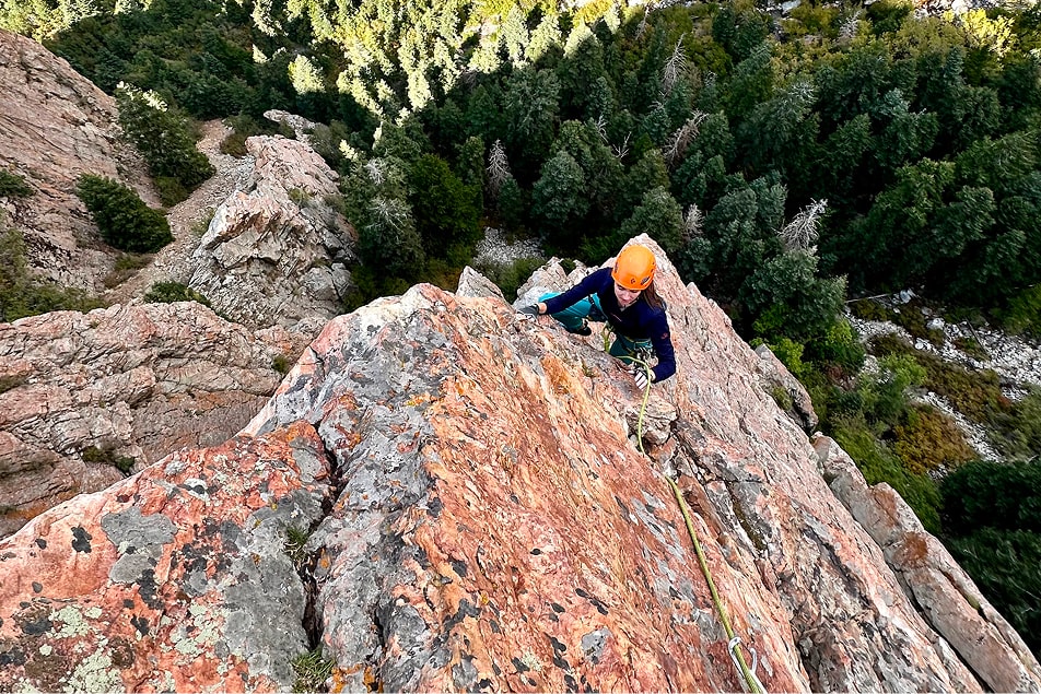 A person climbing high up on a multi-pitch climbing route