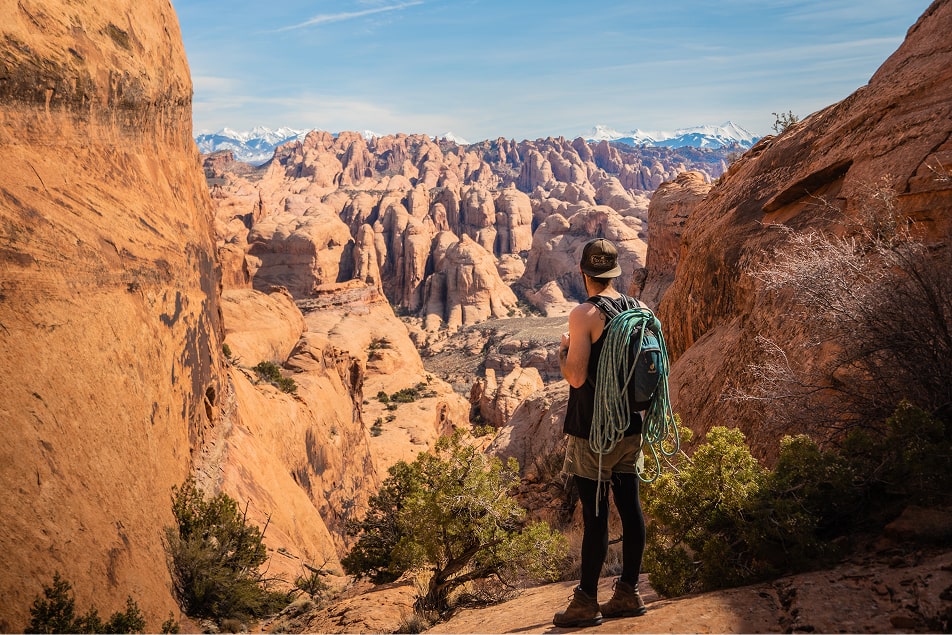 A man with a rope looks out into the distance in moab
