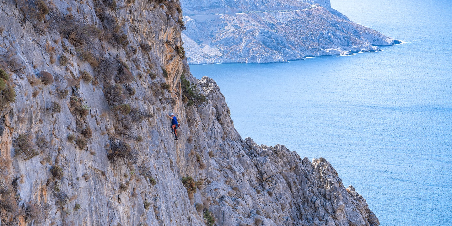 man rock climbing on large rock face above the waters near Kalymnos