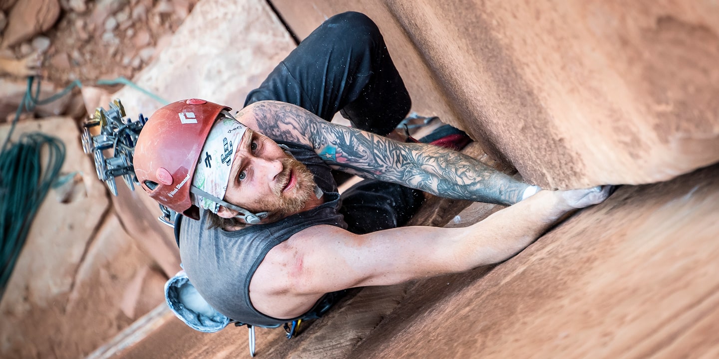 A man who is crack climbing looks up at his next move