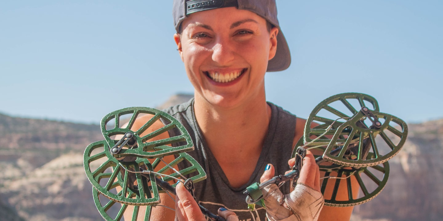 A person hold up large trad climbing equipment