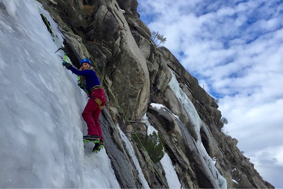 A woman climbing ice during a guided ice climbing trip