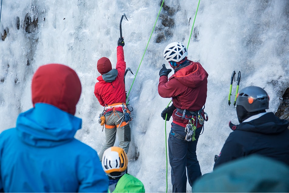People in ice climbing gear, one is teaching the others to ice climb