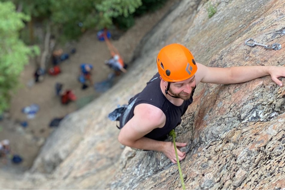 A man climbs a rock during an intro to rock climbing class