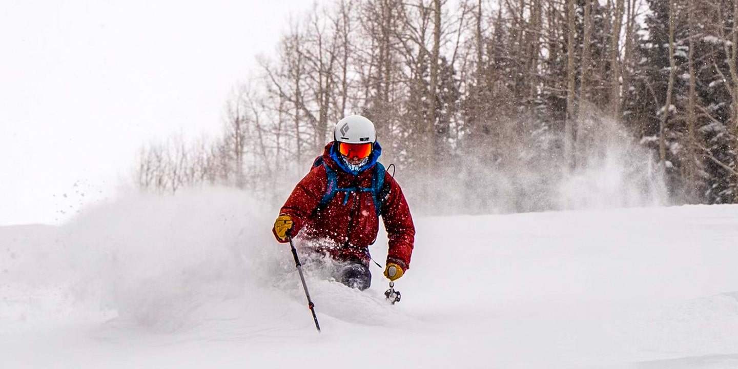 A man backcountry skiing in a red coat
