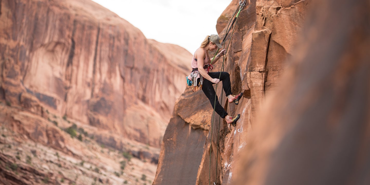 A woman rock climbing on red rock