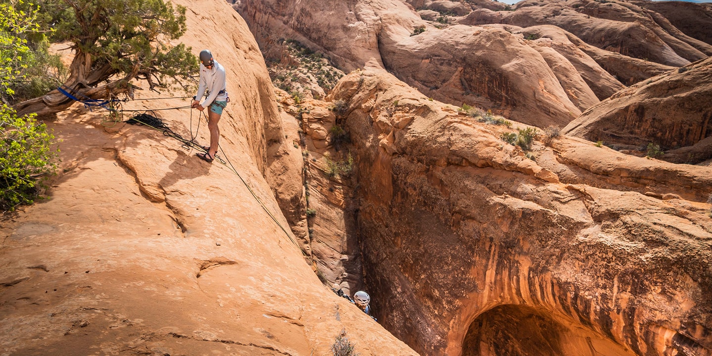 A man repares to rappel down a canyon while canyoneering