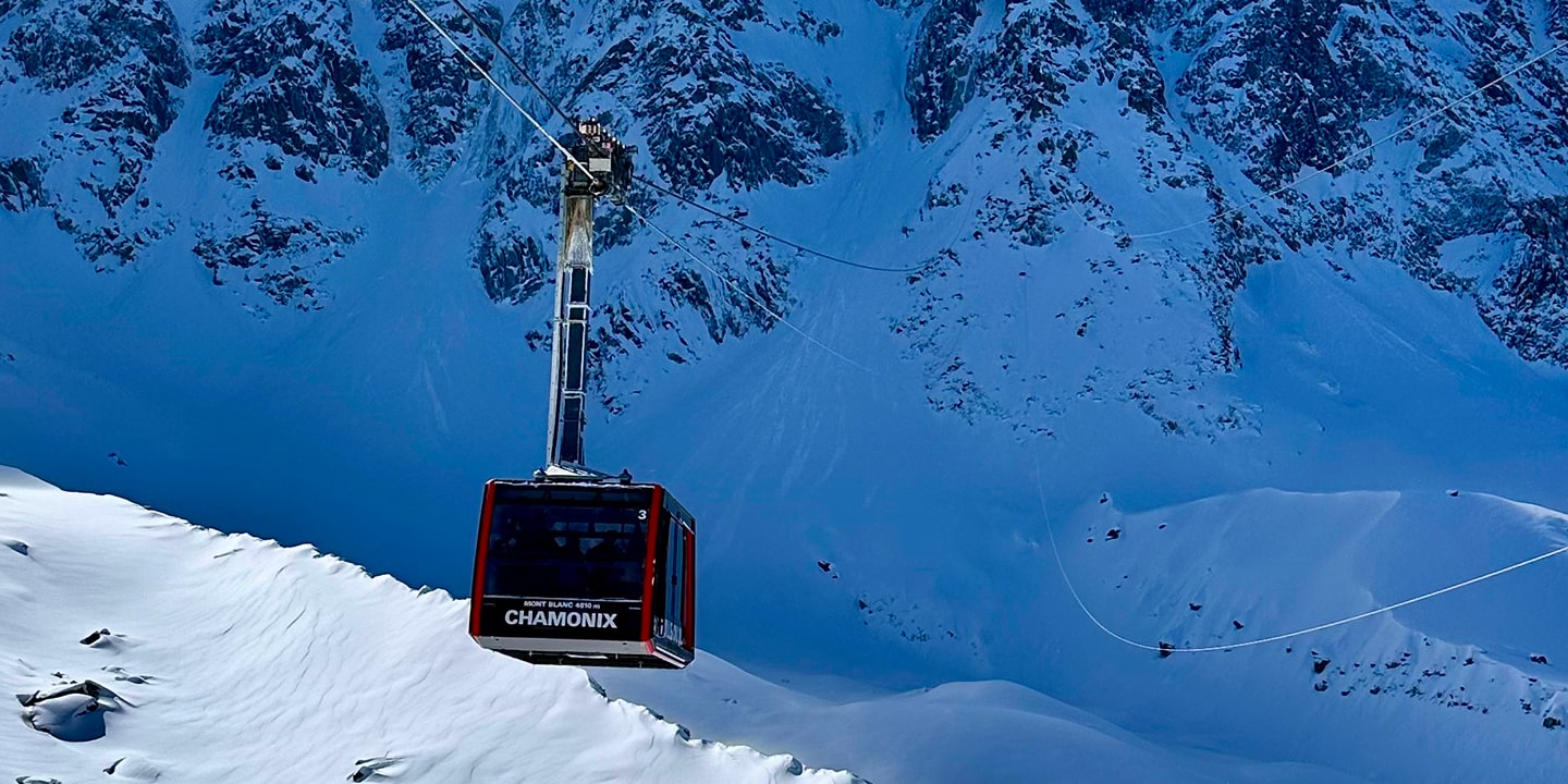 A tram heads to the top of a snowy peak