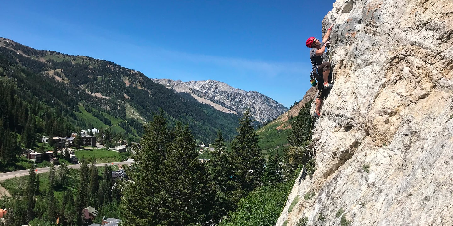 A man multi-pitch rock climbing in a scenic location