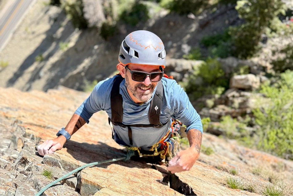 A man in the middle of his rock climbing route