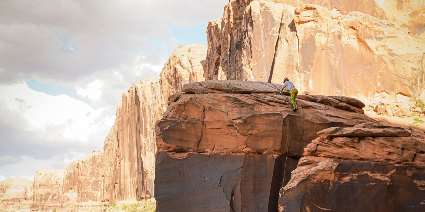 A person gets to the top of their climbing route