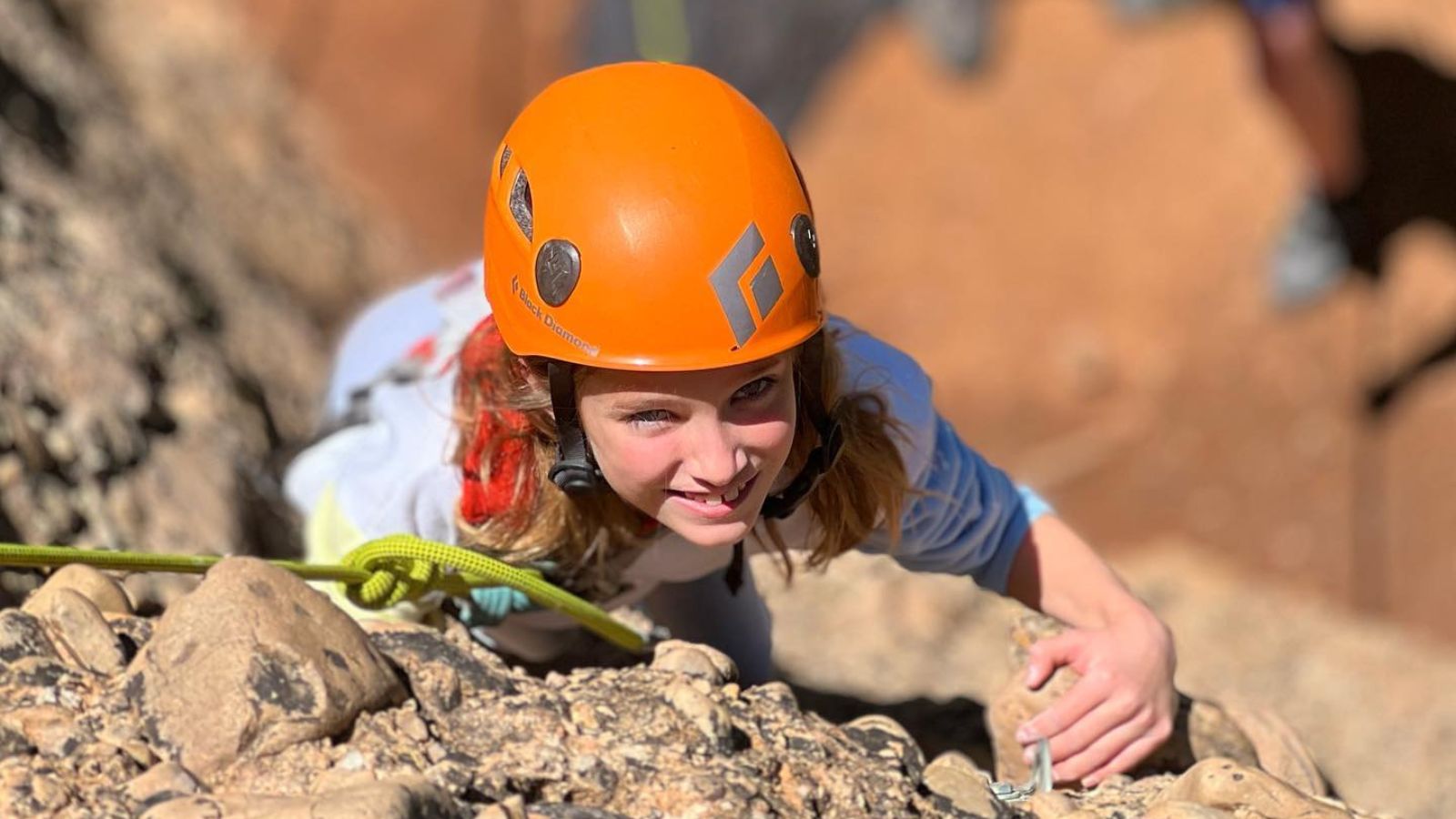 a girl rock climbs with a guide in moab utah