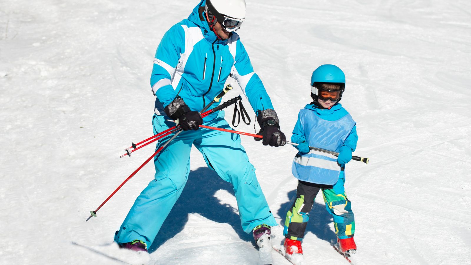 A father teaching his son to ski at a Uth ski resort