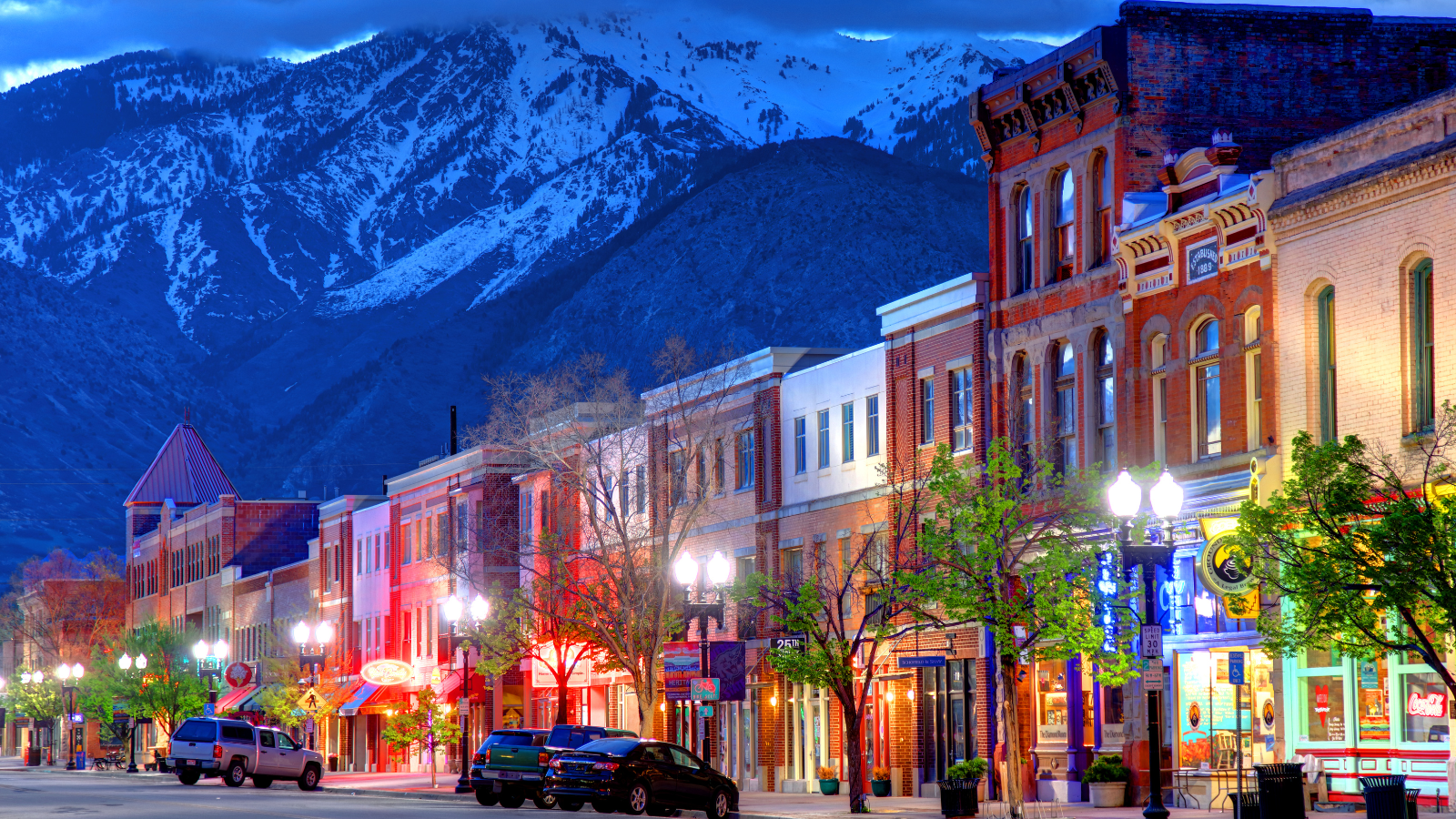 Downtown Ogden, lit up with lights with a snowy mountian